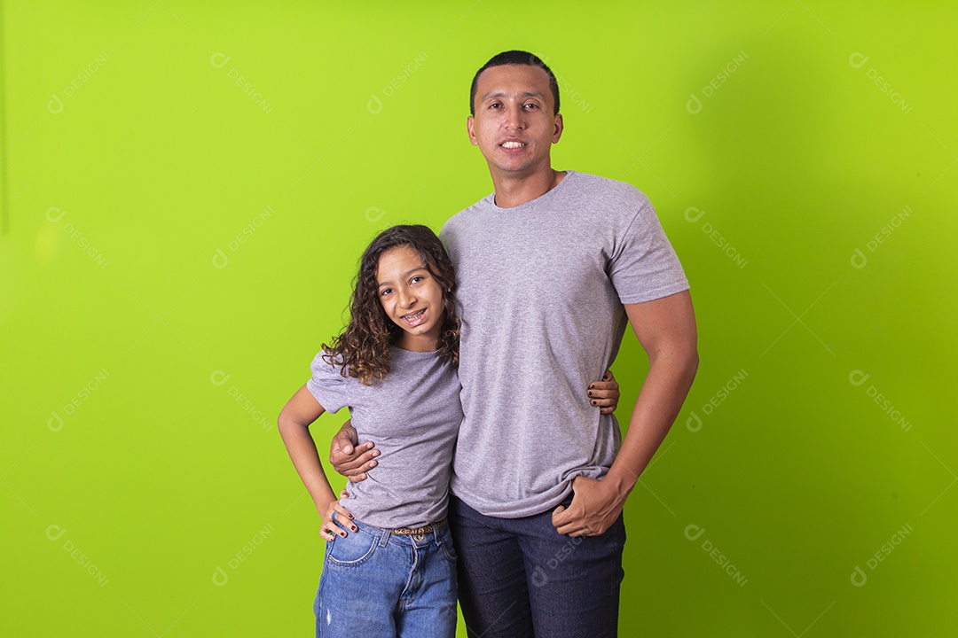 Pai e filha juntos combinando em fundo verde