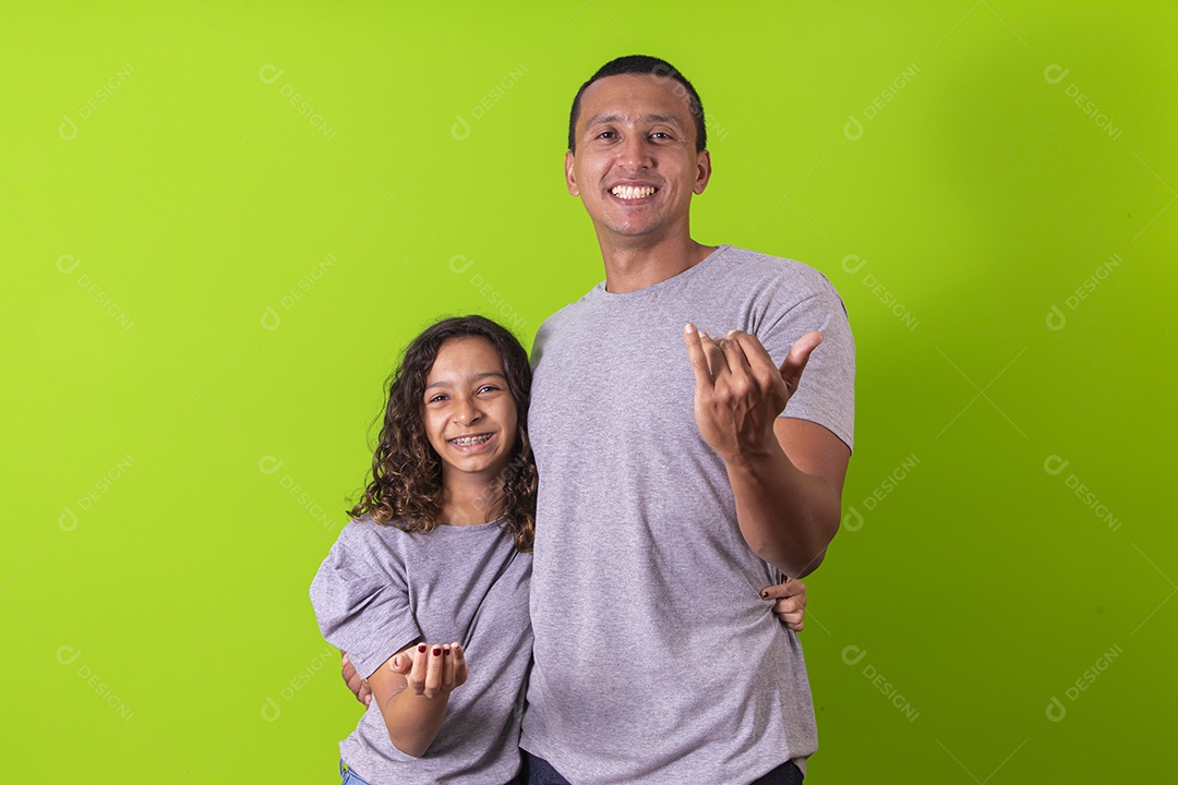 Pai e filha juntos combinando em fundo verde