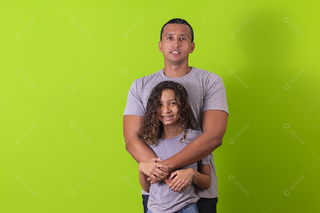 Pai e filha juntos combinando em fundo verde