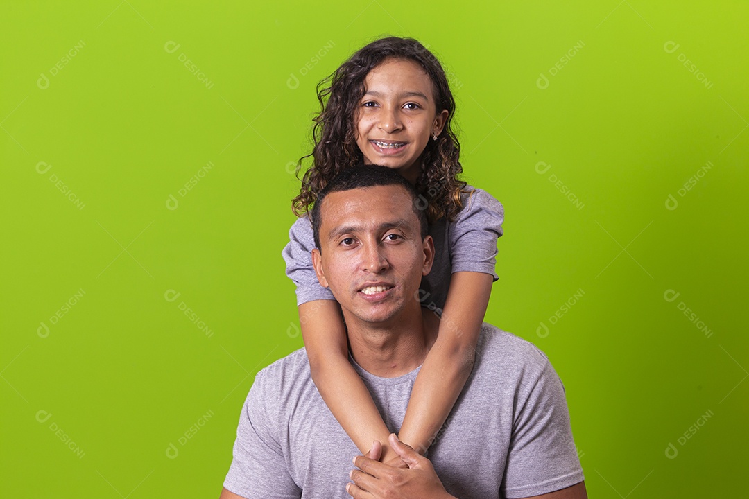 Pai e filha juntos combinando em fundo verde