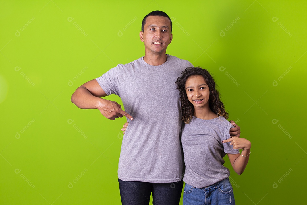 Pai e filha juntos combinando em fundo verde