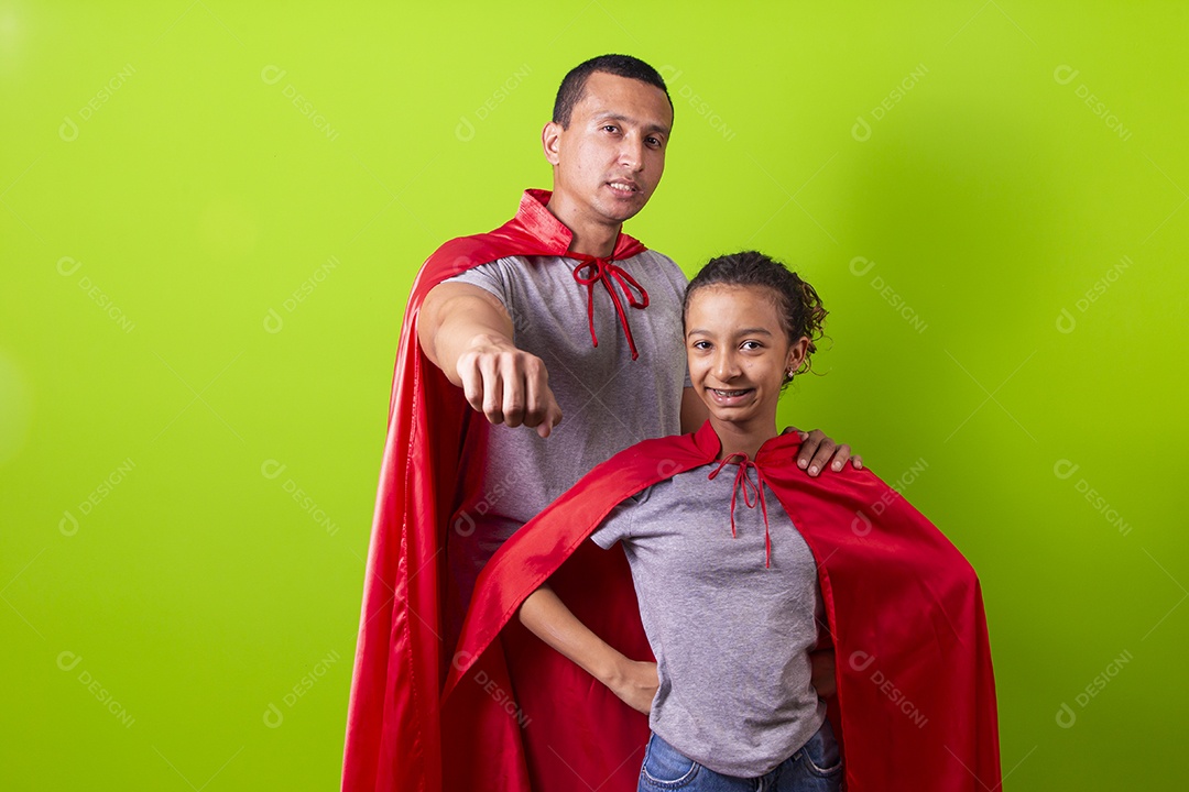 Pai e filha juntos com capa de super herói em fundo verde