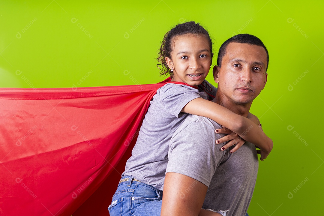 Pai e filha juntos com capa de super herói em fundo verde