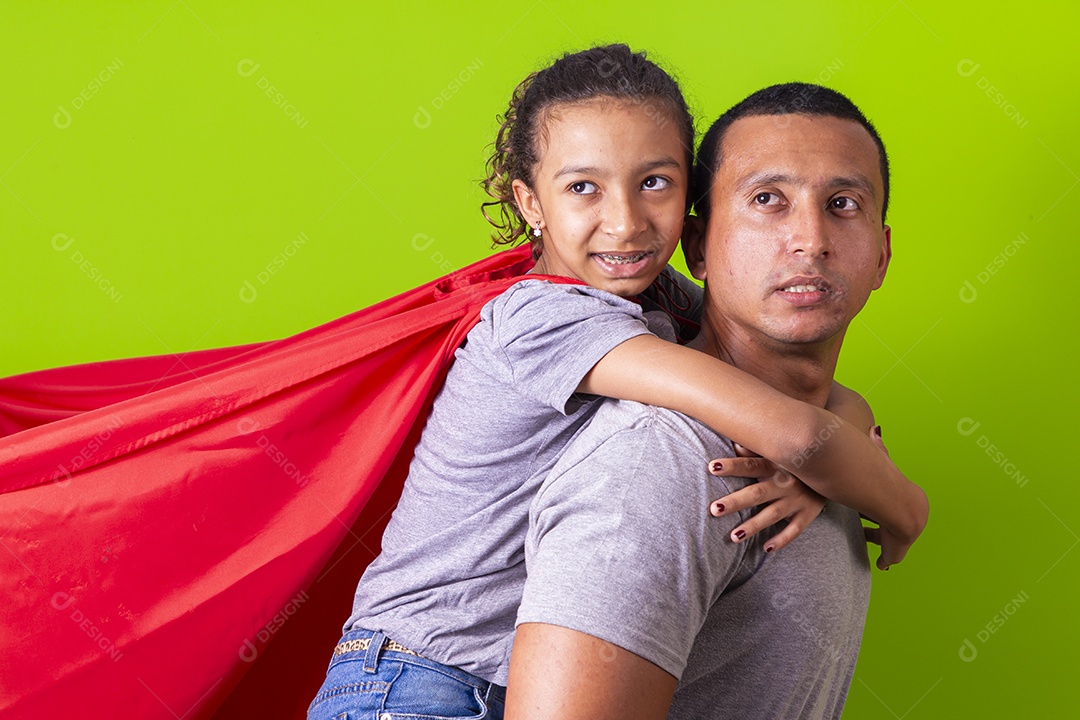 Pai e filha juntos com capa de super herói em fundo verde