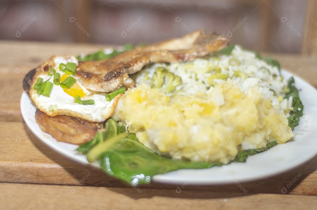 Comida caseira com arroz, ovos, carne de porco, couve-flor e iguarias