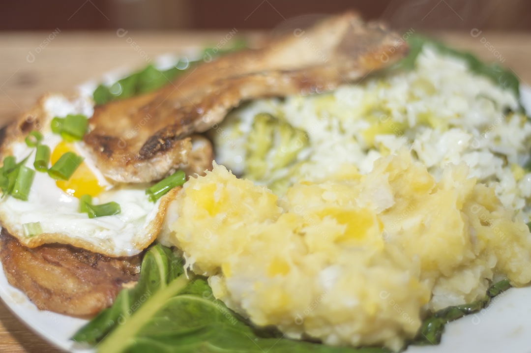 Comida caseira com arroz, ovos, carne de porco, couve-flor e iguarias