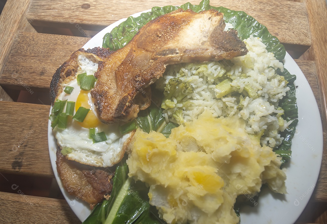 Comida caseira com arroz, ovos, carne de porco, couve-flor e iguarias