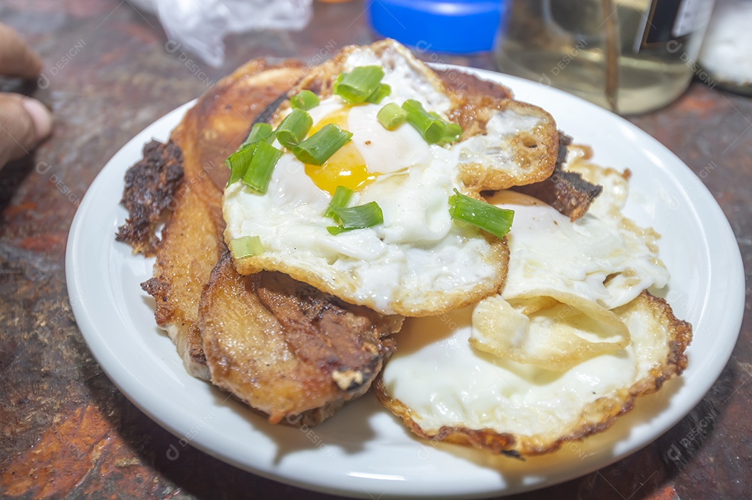 Comida caseira com arroz, ovos, carne de porco, couve-flor e iguarias
