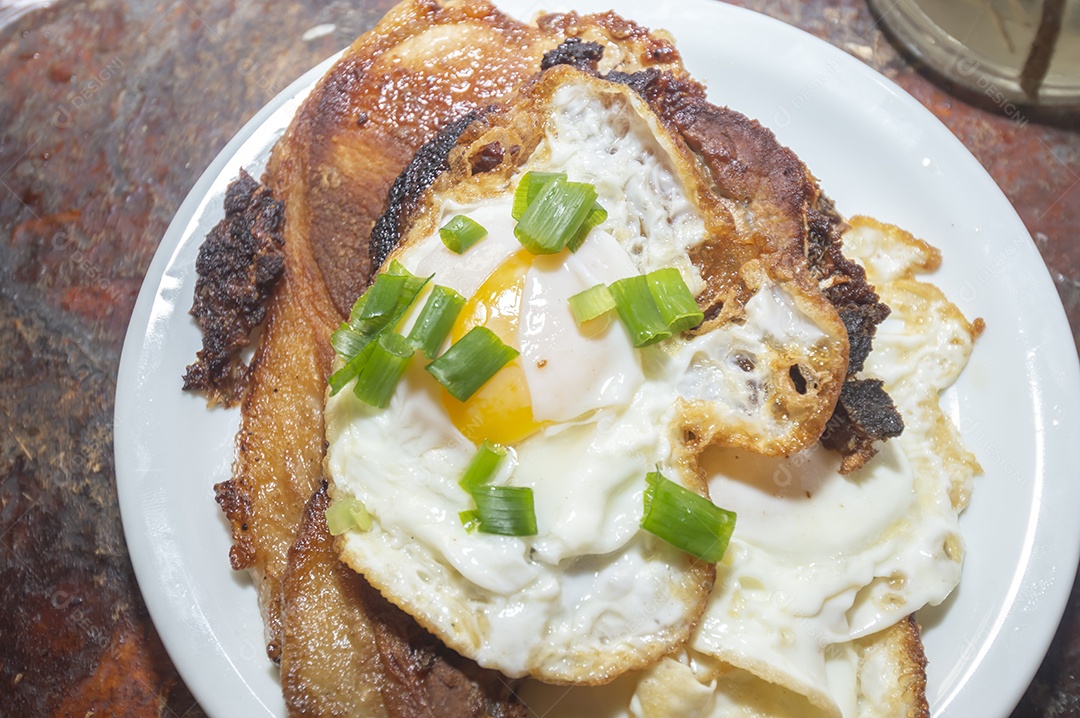 Comida caseira com arroz, ovos, carne de porco, couve-flor e iguarias