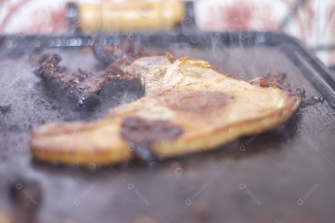 Bife suíno sendo grelhado