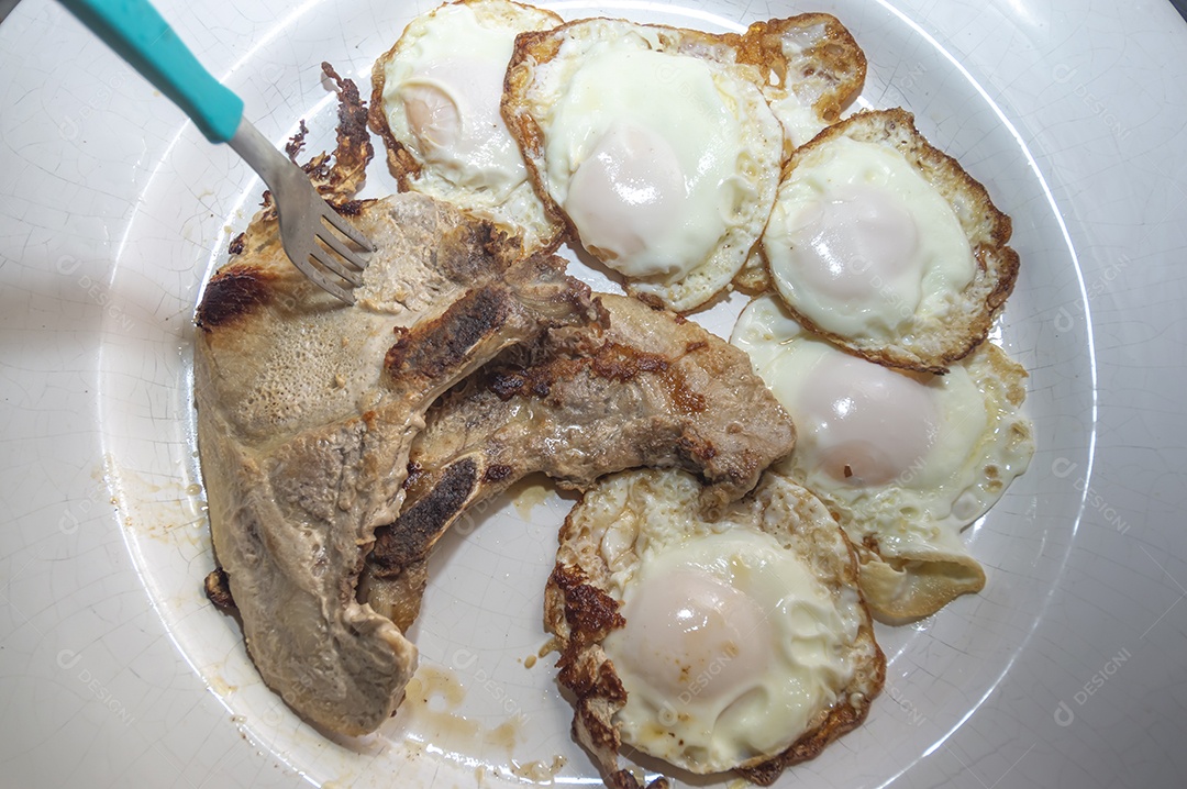 Comida caseira com arroz, ovos, carne de porco, couve-flor e iguarias