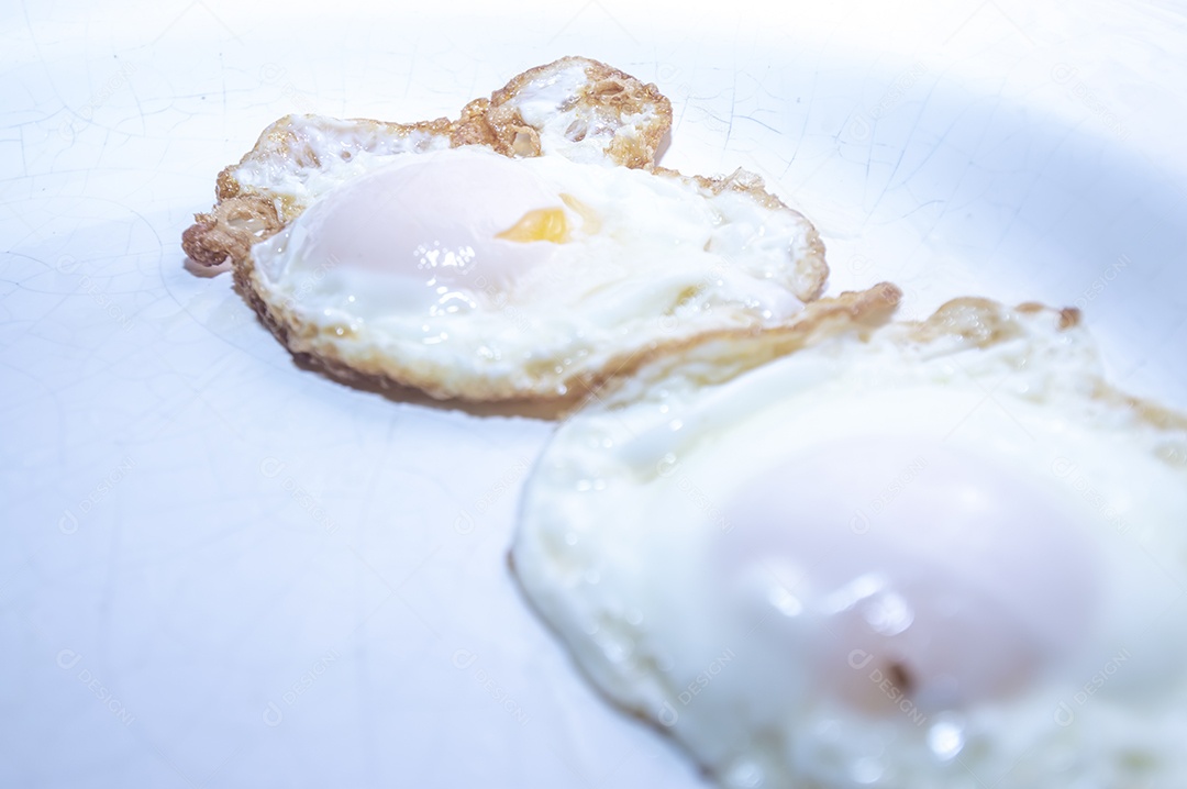 Ovo frito em prato branco com luz natural, foto indicada para recorte.