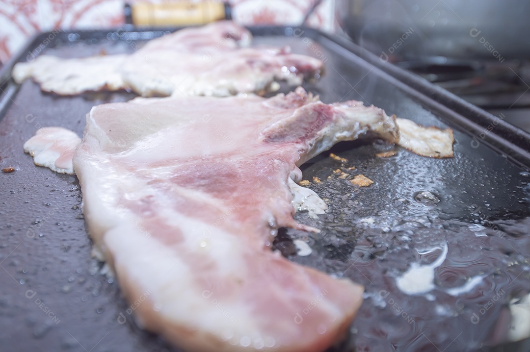 Bife suíno em um churrasco caseiro que fica em cima do fogão