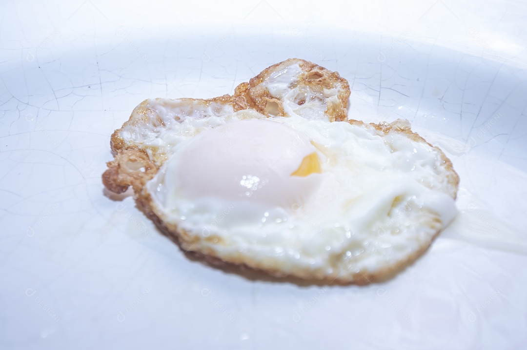 Ovo frito em prato branco com luz natural, foto indicada para recorte.