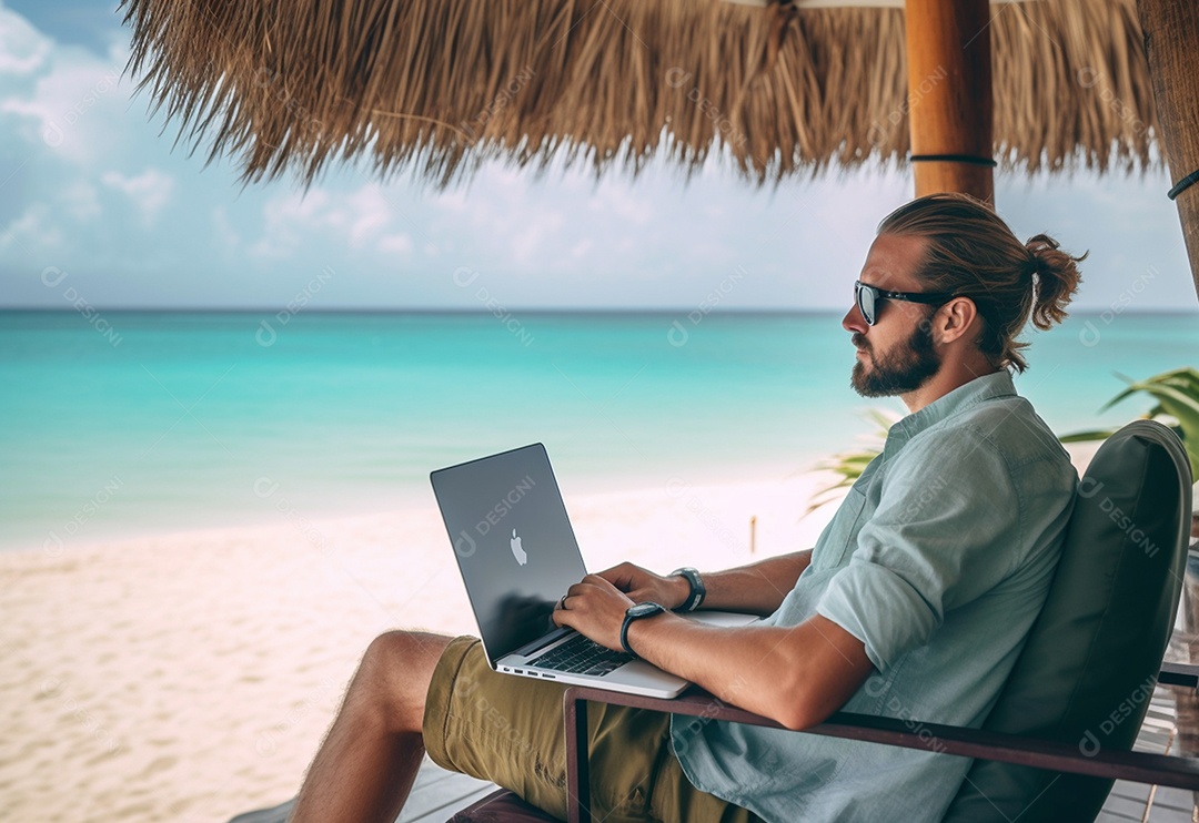 Homem trabalhando em um laptop na praia