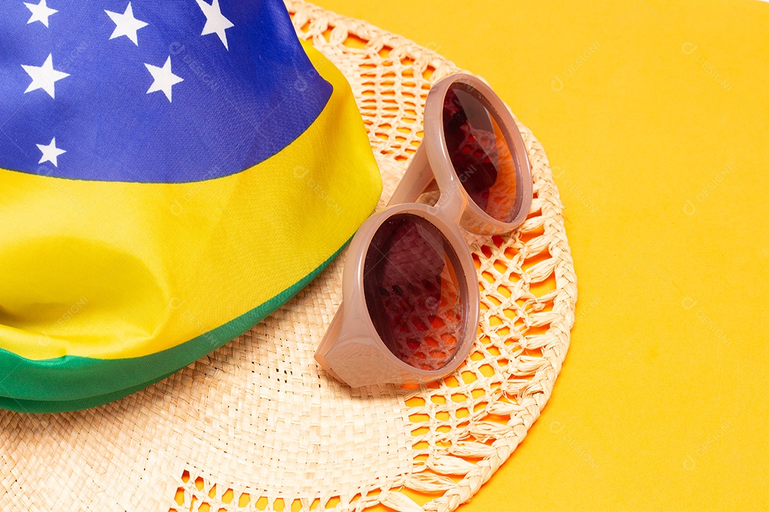 Óculos de sol e um chapéu na bandeira brasileira
