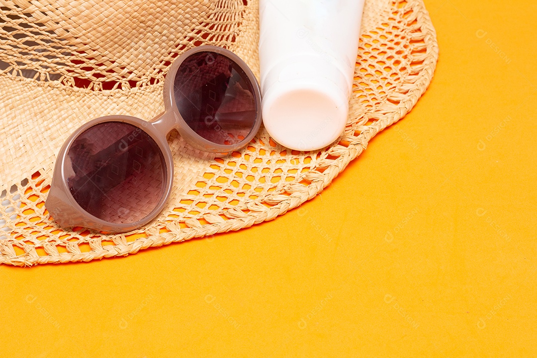 Óculos de sol e um protetor solar no fundo amarelo