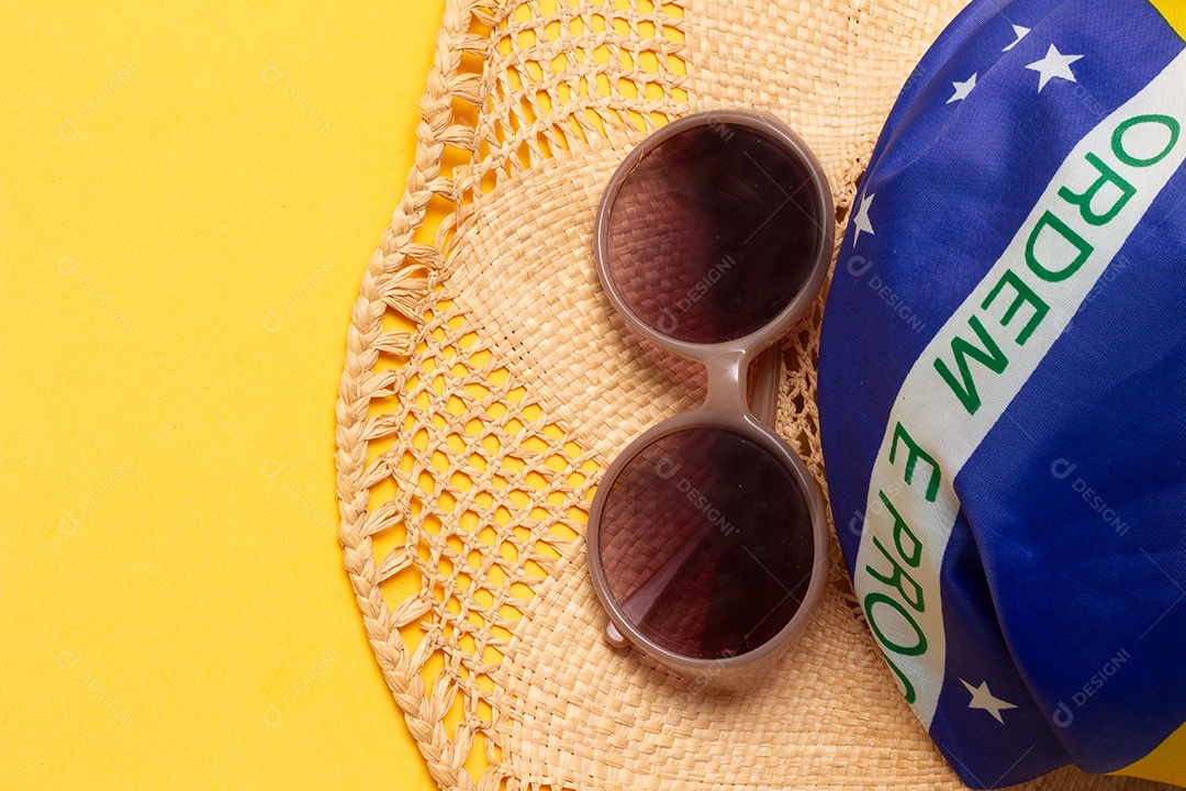 Óculos de sol e um chapéu na bandeira brasileira