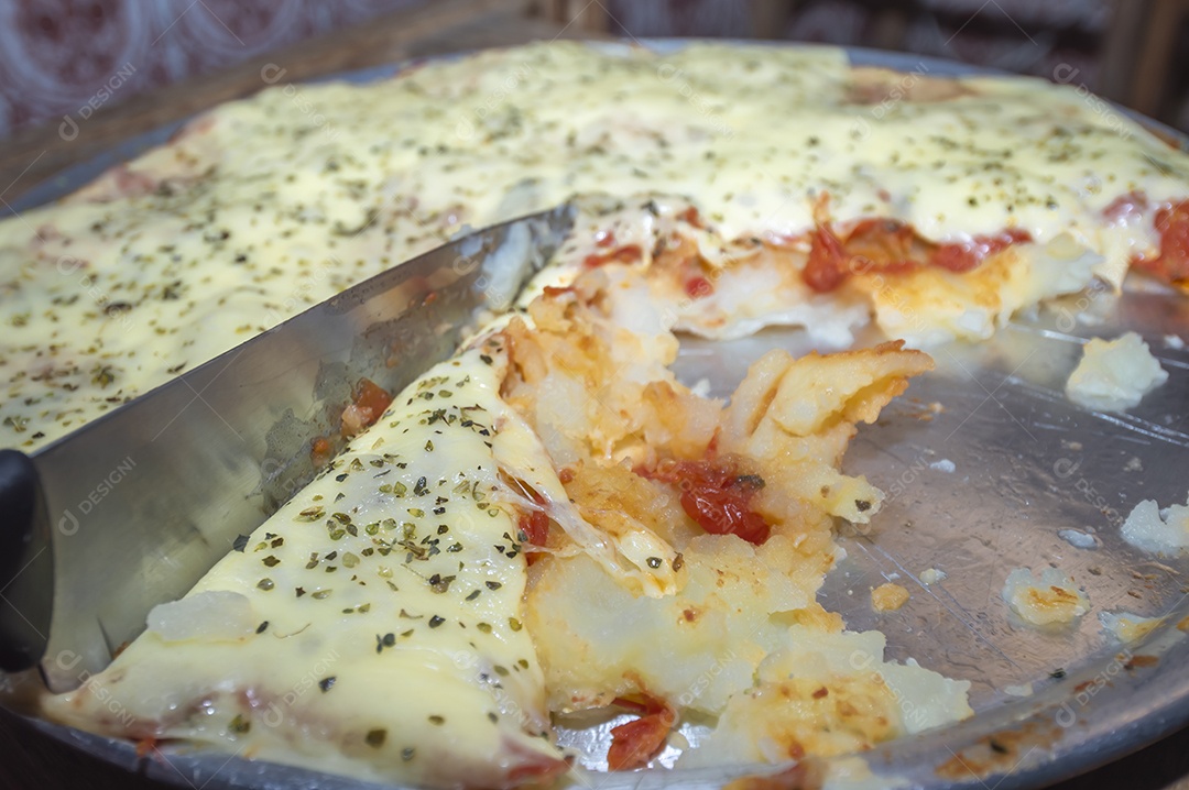 Pizza feita com massa de batata, queijo manjericão e orégano