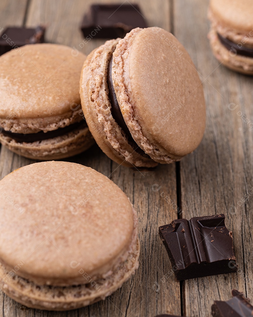 Macarons de chocolate escuro sobre fundo de madeira