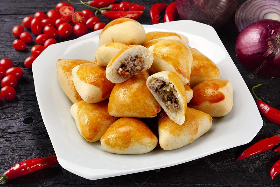 Várias esfirras de carne em um prato branco