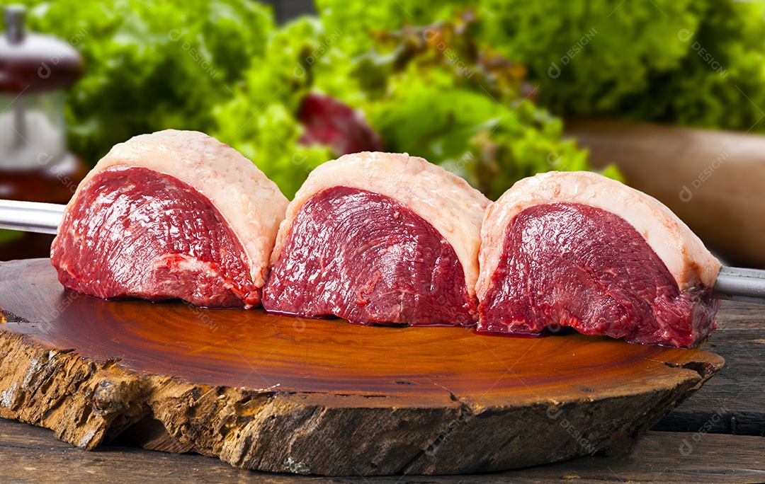 Espeto de picanha crua sobre uma tabua de madeira