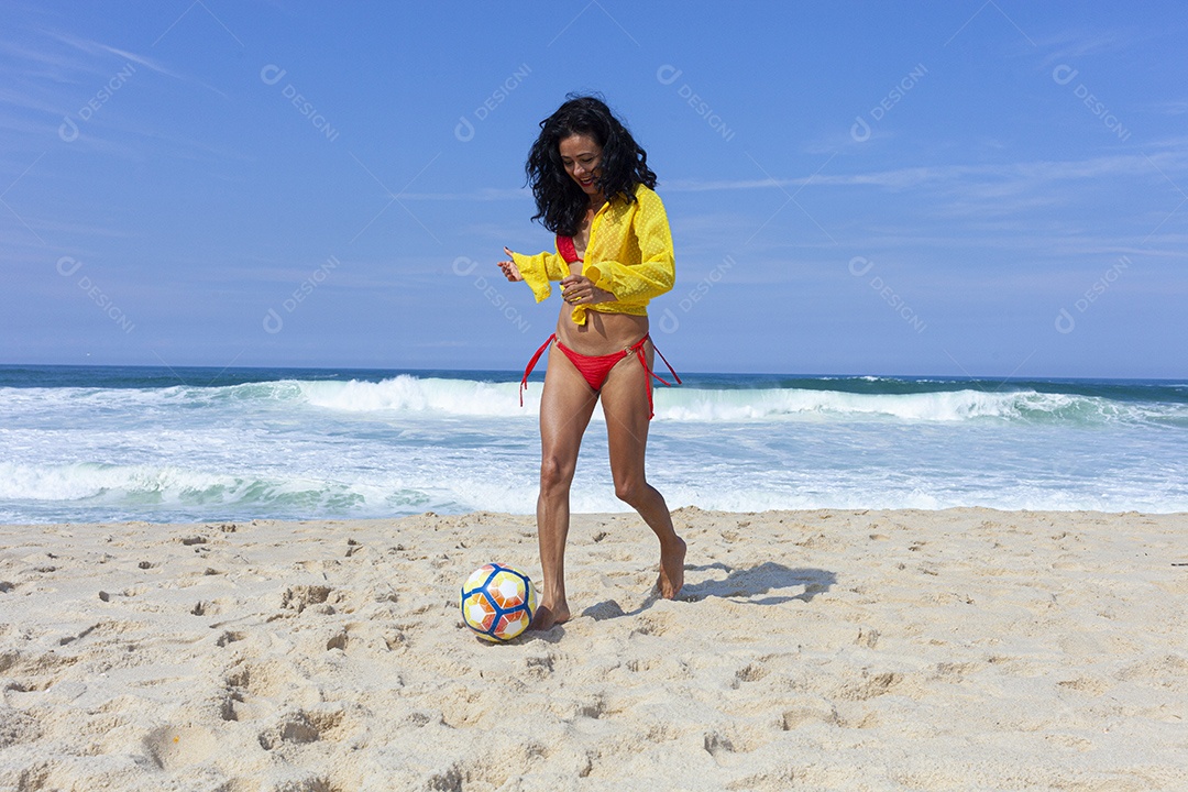 Mulher jogando bola na praia