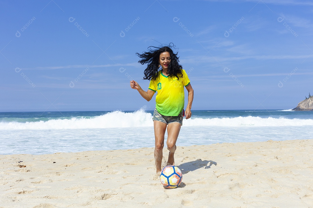 Mulher jogando futebol na praia