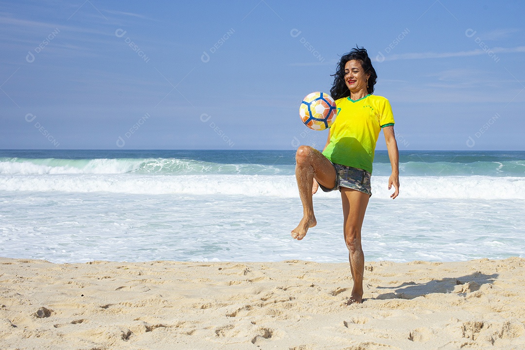 Mulher jogando futebol na praia