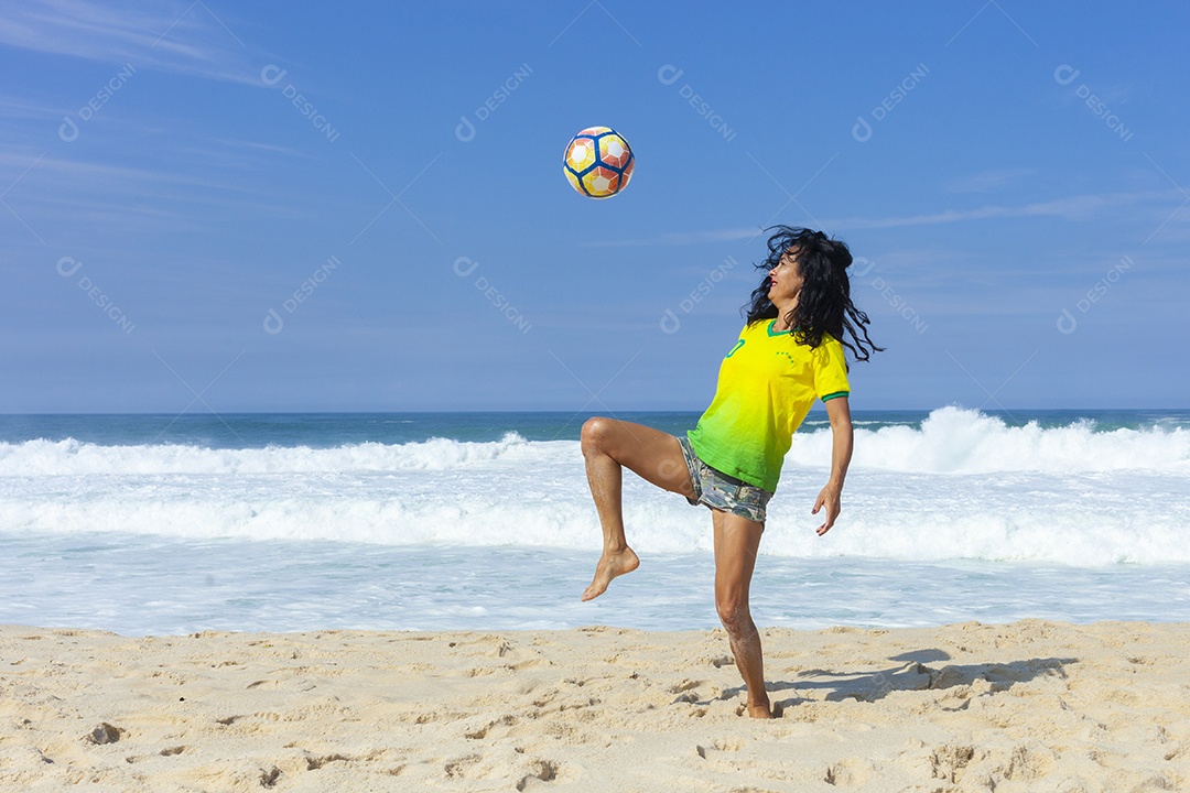 Mulher jogando futebol na praia