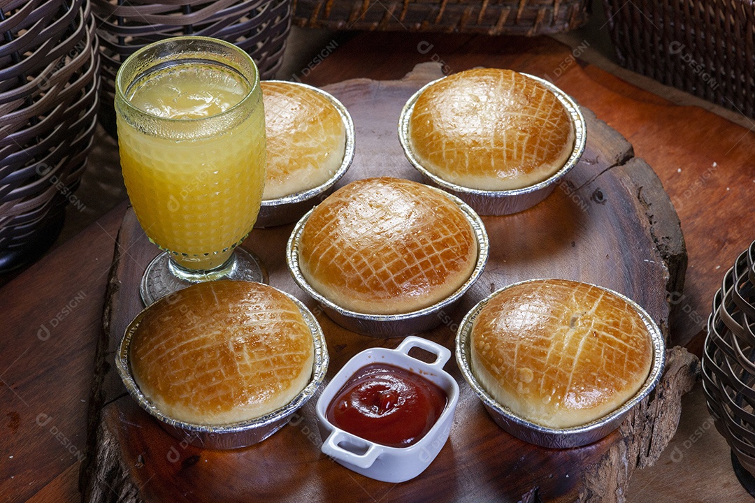 Empadas e suco sobre uma tabua de madeira