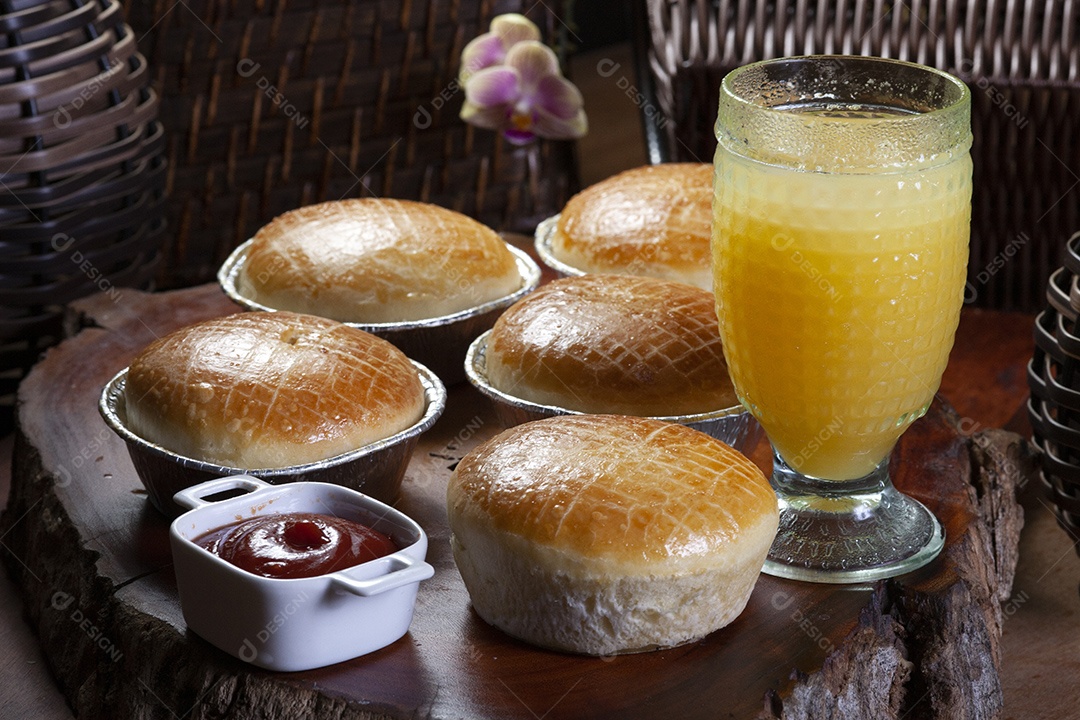 Empadas e suco sobre uma tabua de madeira