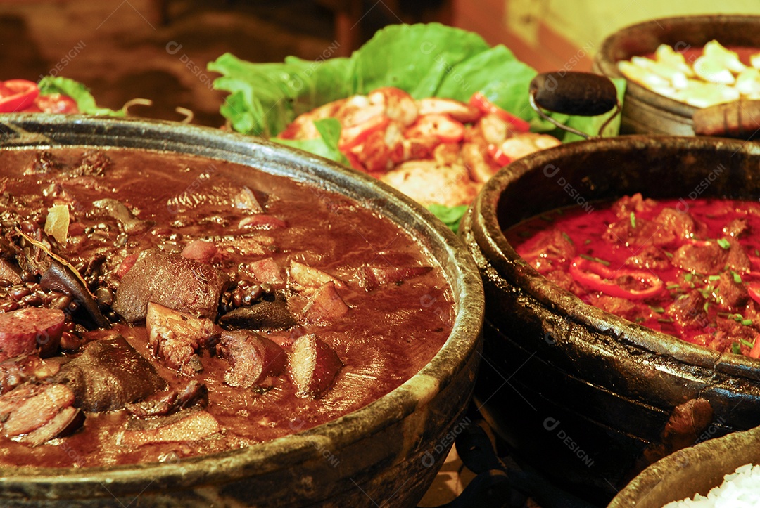 Feijoada e carne cozida sobre um fogão caipira