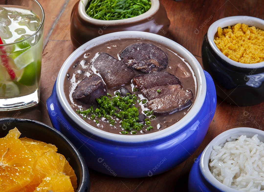 Feijoada com acompanhamentos e copo de caipirinha