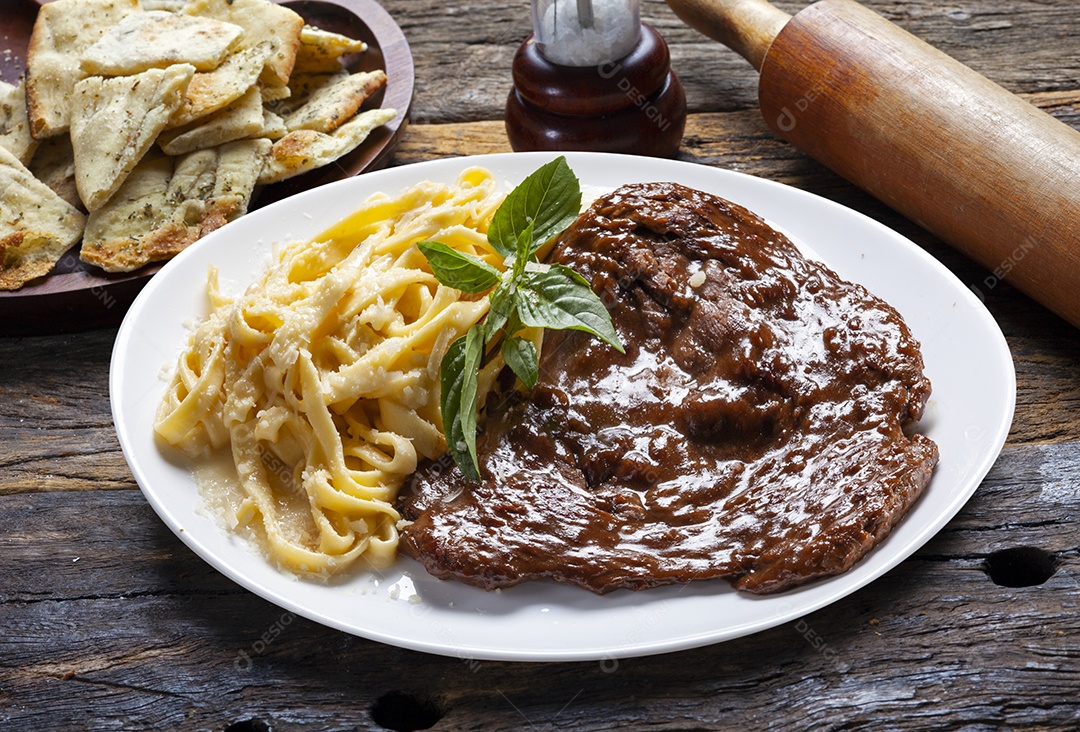Bife assado com molho e macarrão