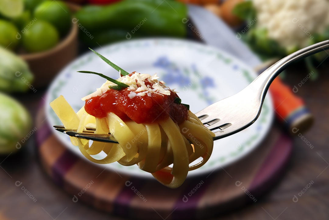 Macarrão com molho de tomate no garfo