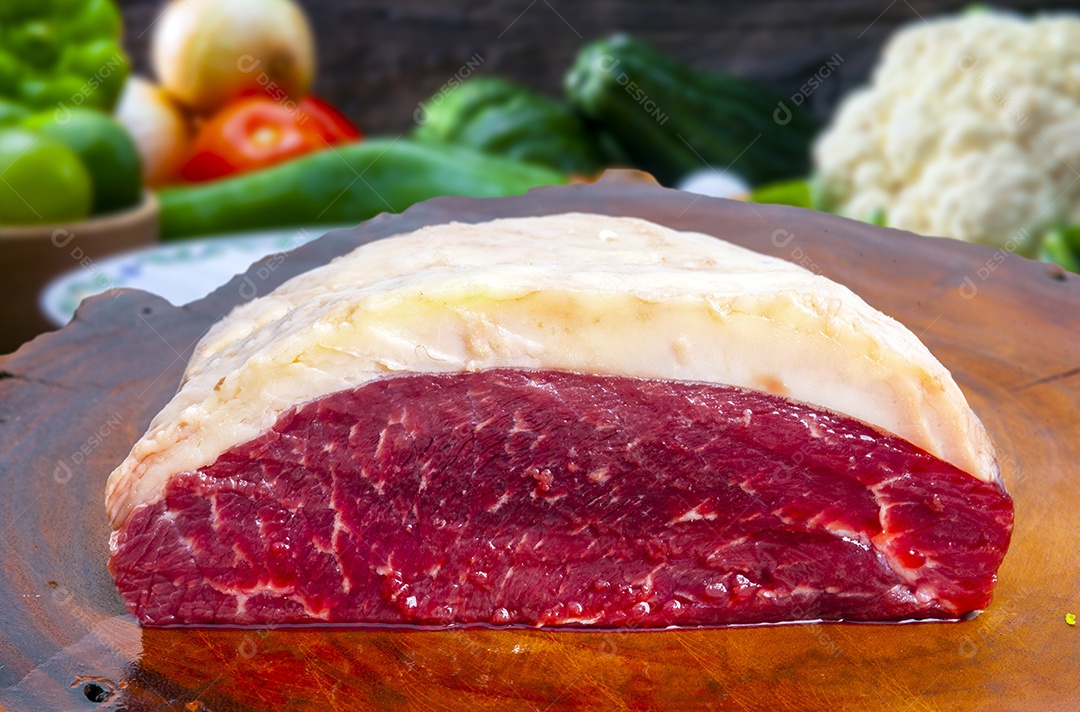 Peça de picanha sobre tabua de madeira