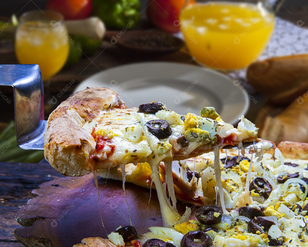 Fatia de pizza e suco ao fundo