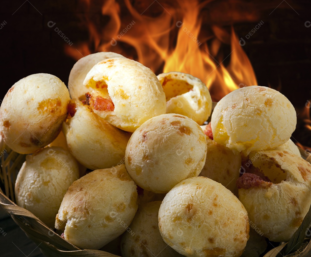 Pães de queijo em cesta sobre mesa de madeira