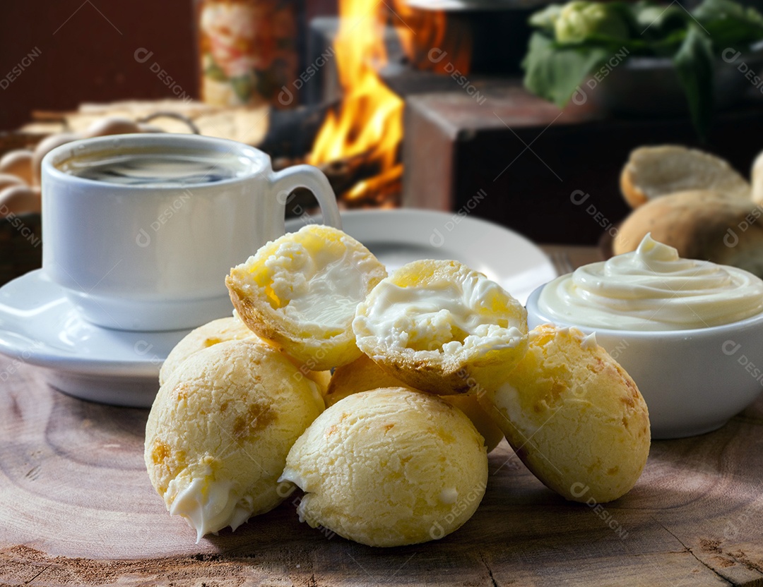 Pães de queijo com catupiry sobre mesa de madeira e xícara de café