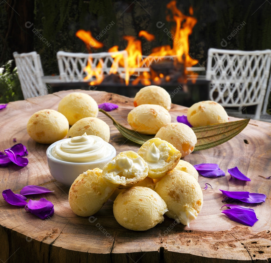 Pães de queijo com catupiry e cheddar sobre uma tabua de madeira