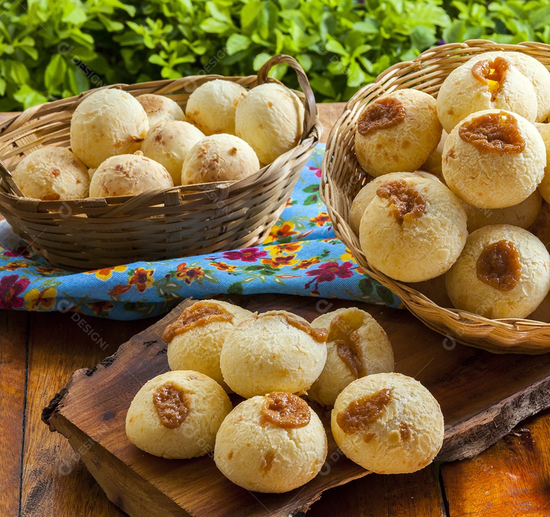 Pães de queijo recheados sobre mesa de madeira