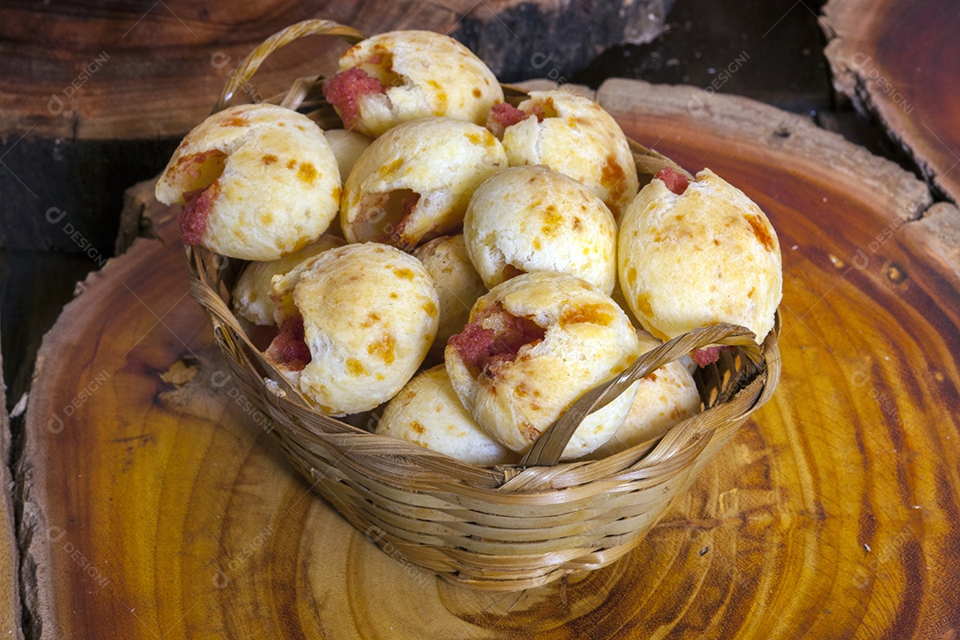 Pão de queijo em cesta de madeira sobre tabua