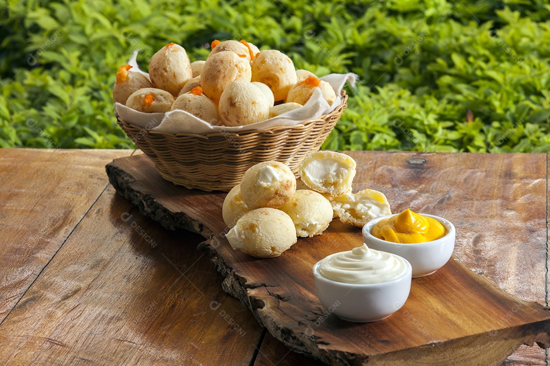 Pães de queijo com catupiry e cheddar sobre uma tabua de madeira