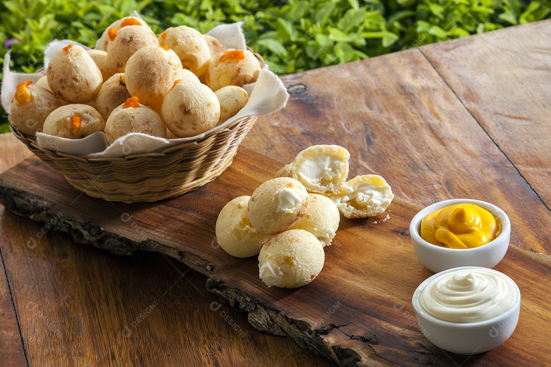 Pães de queijo com catupiry e cheddar sobre uma tabua de madeira