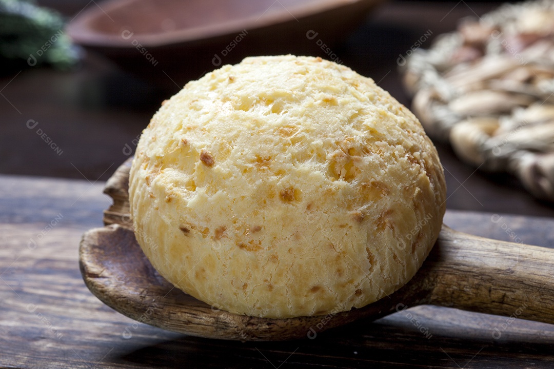 Pão de queijo sobre uma colher de madeira