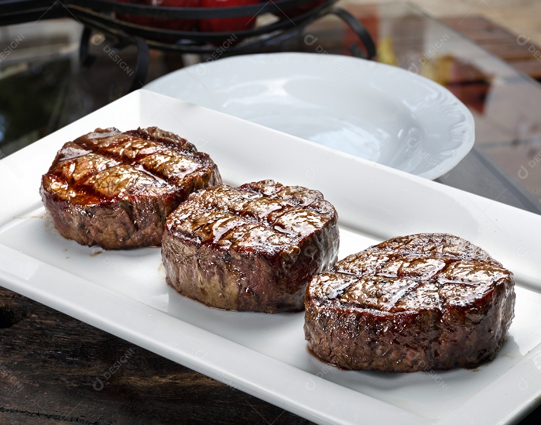 Três bifes assados ​​na grelha