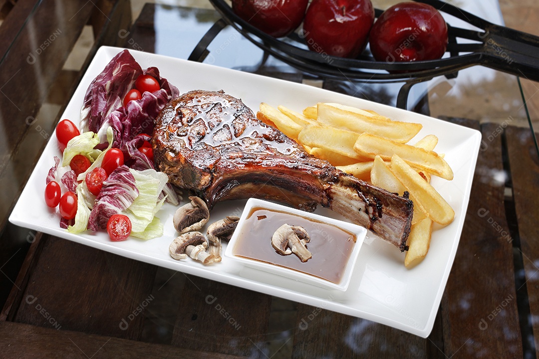 Bife tomahawk assado com batata frita e salada