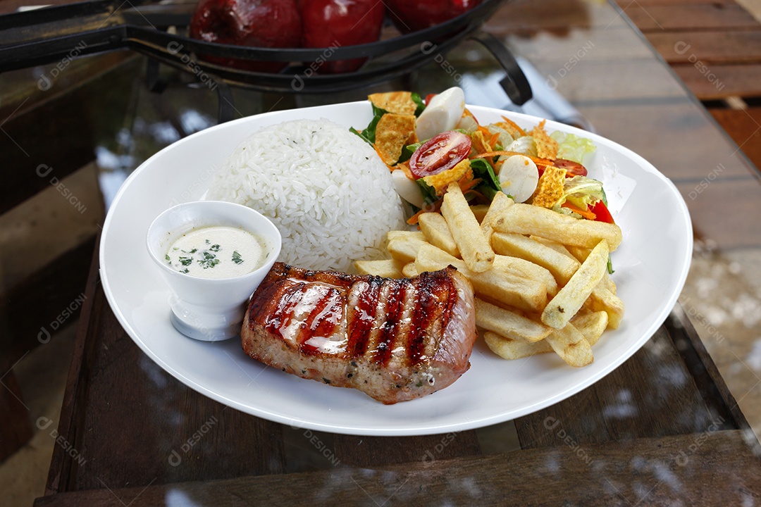 Prato com arroz carne batatas salada e molho