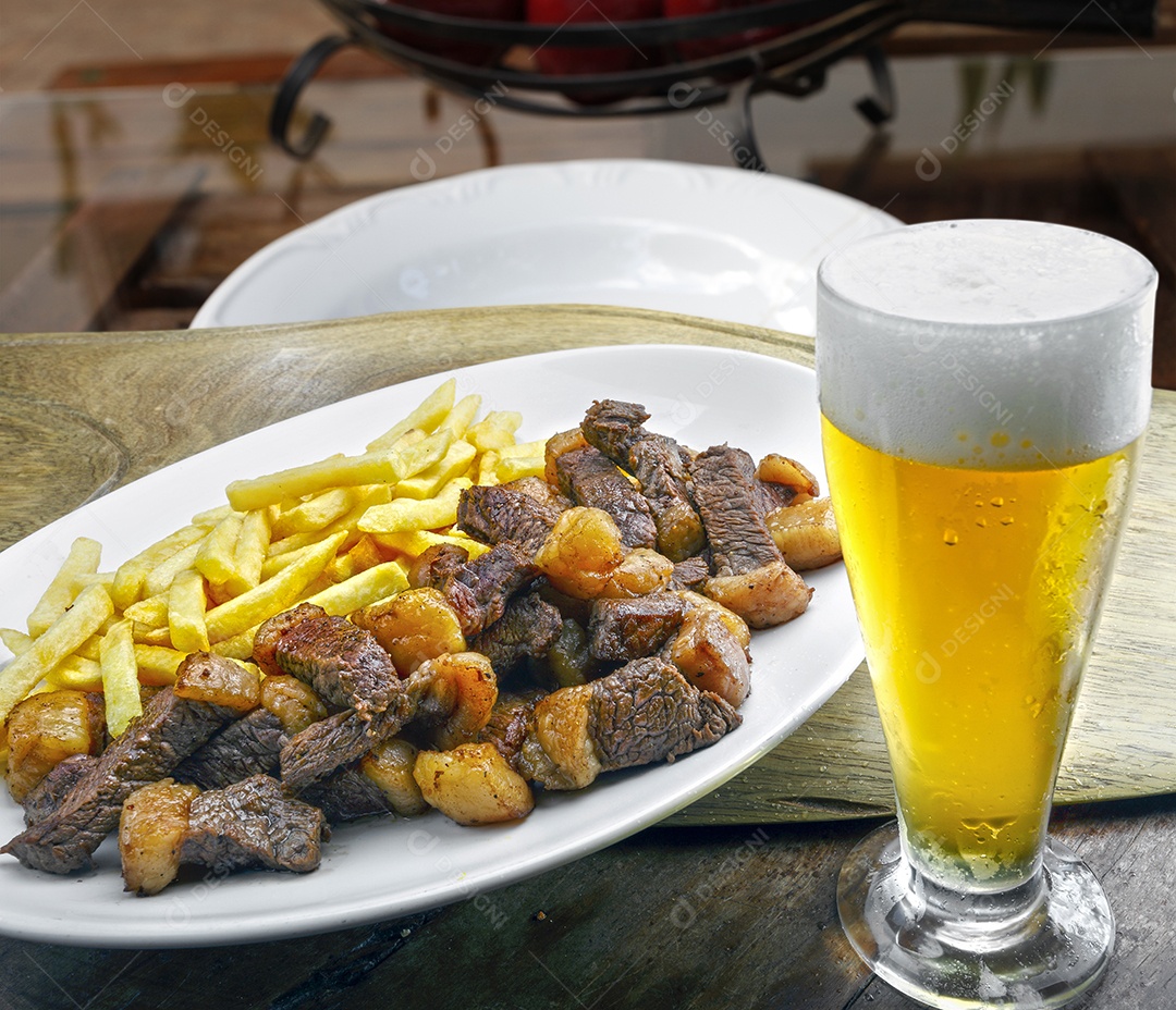 Tiras de carne frita com batatas e copo de cerveja